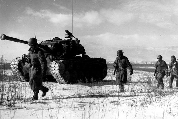 A column of troops and armor of the 1st Marine Division move through communist Chinese lines during their successful breakout from the Chosin Reservoir in North Korea. The Marines were besieged when the Chinese entered the Korean War on Nov. 27, 1950, by sending 200,000 shock troops against Allied forces. (Cpl. Peter McDonald/U.S. Marine Corps photo) Korean War 1st Marine Division